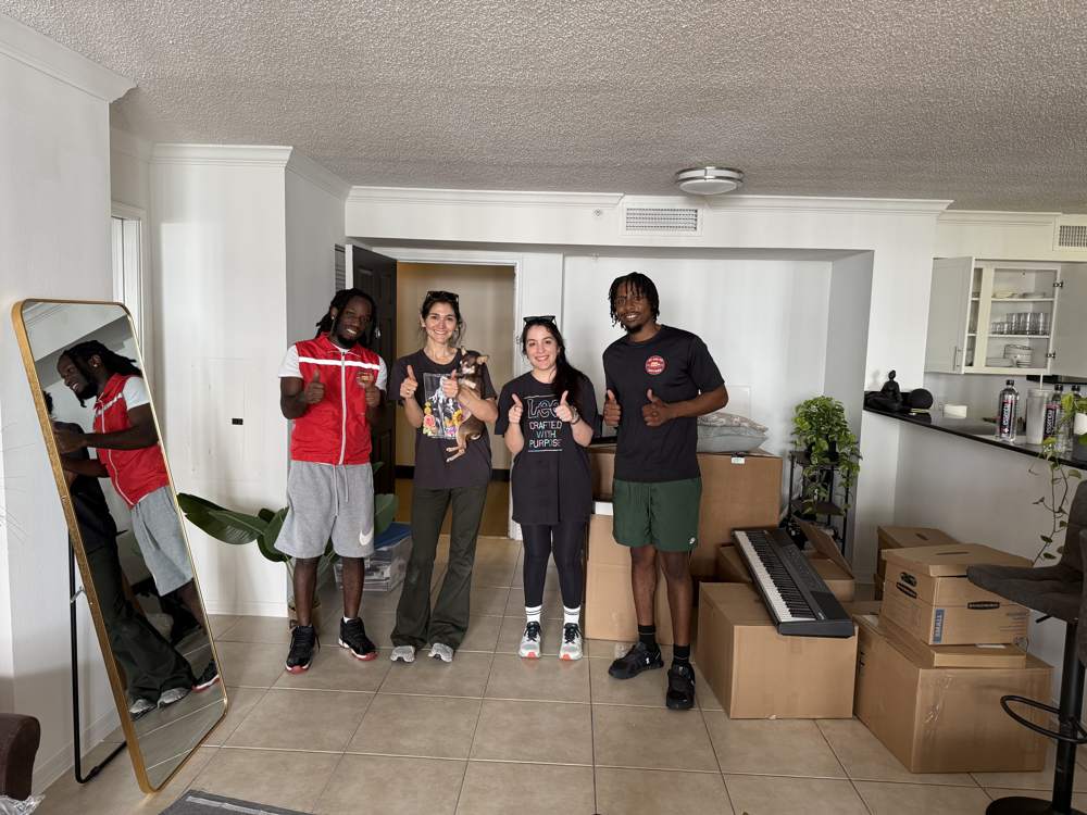 Up and Up Movers crew wrapping and loading furniture into a moving truck